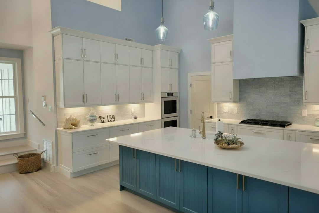 Modern kitchen with blue and white cabinets, island, and appliances.